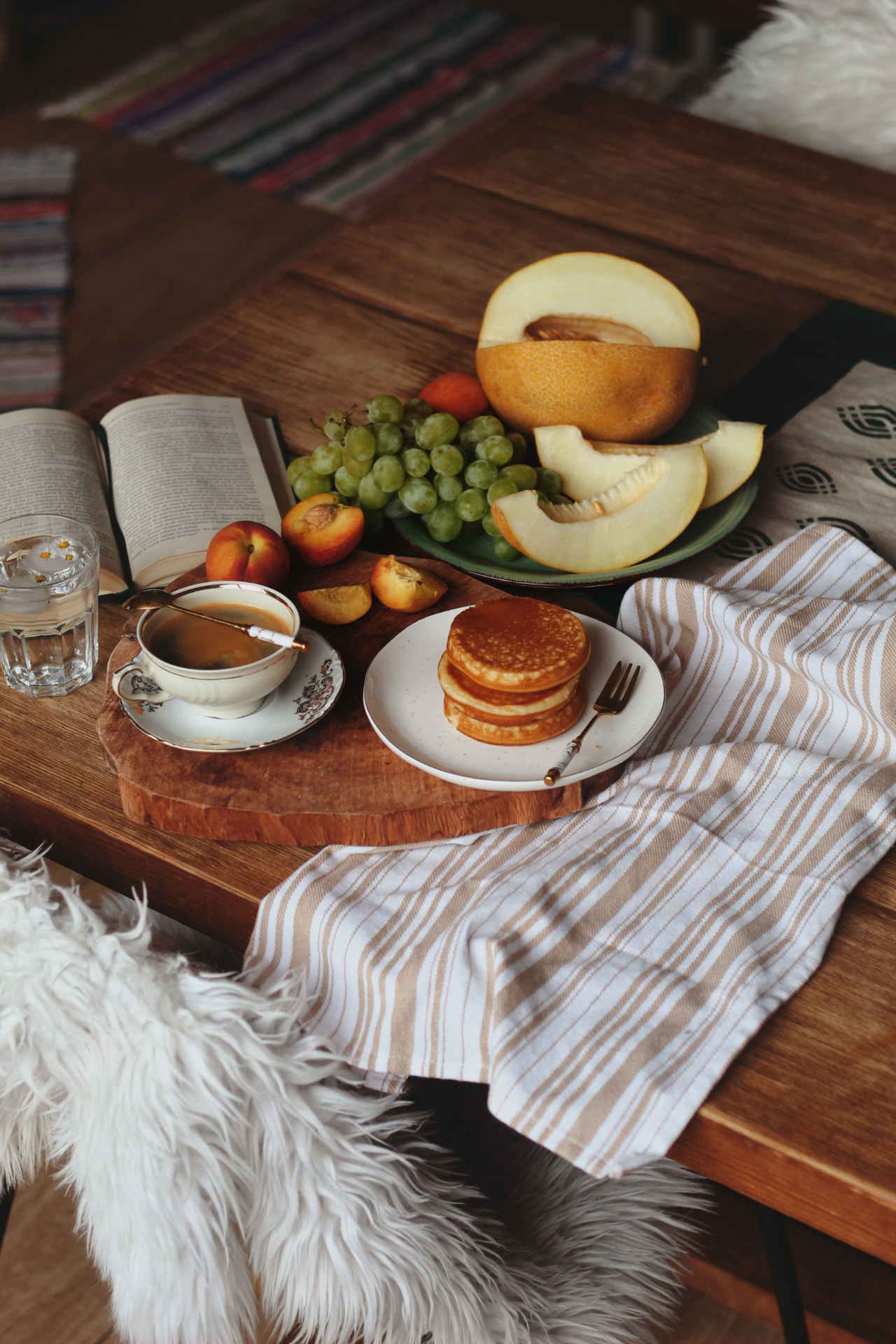 Mesa de madeira com frutas, livro e café