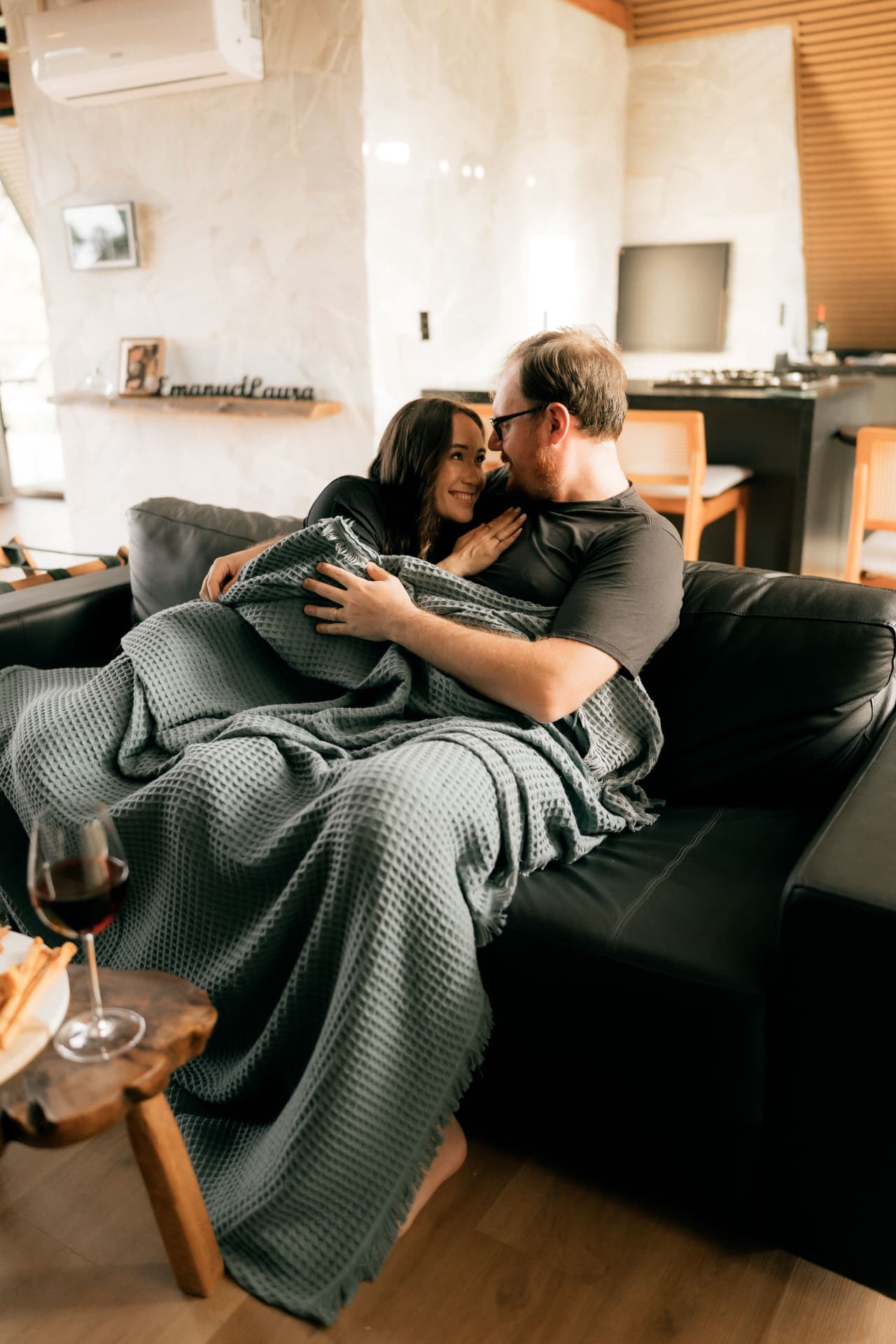 Casal abraçado no sofá da sala